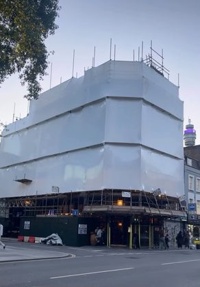 Multi-storey building in Tottenham fully encapsulated in white shrink wrap